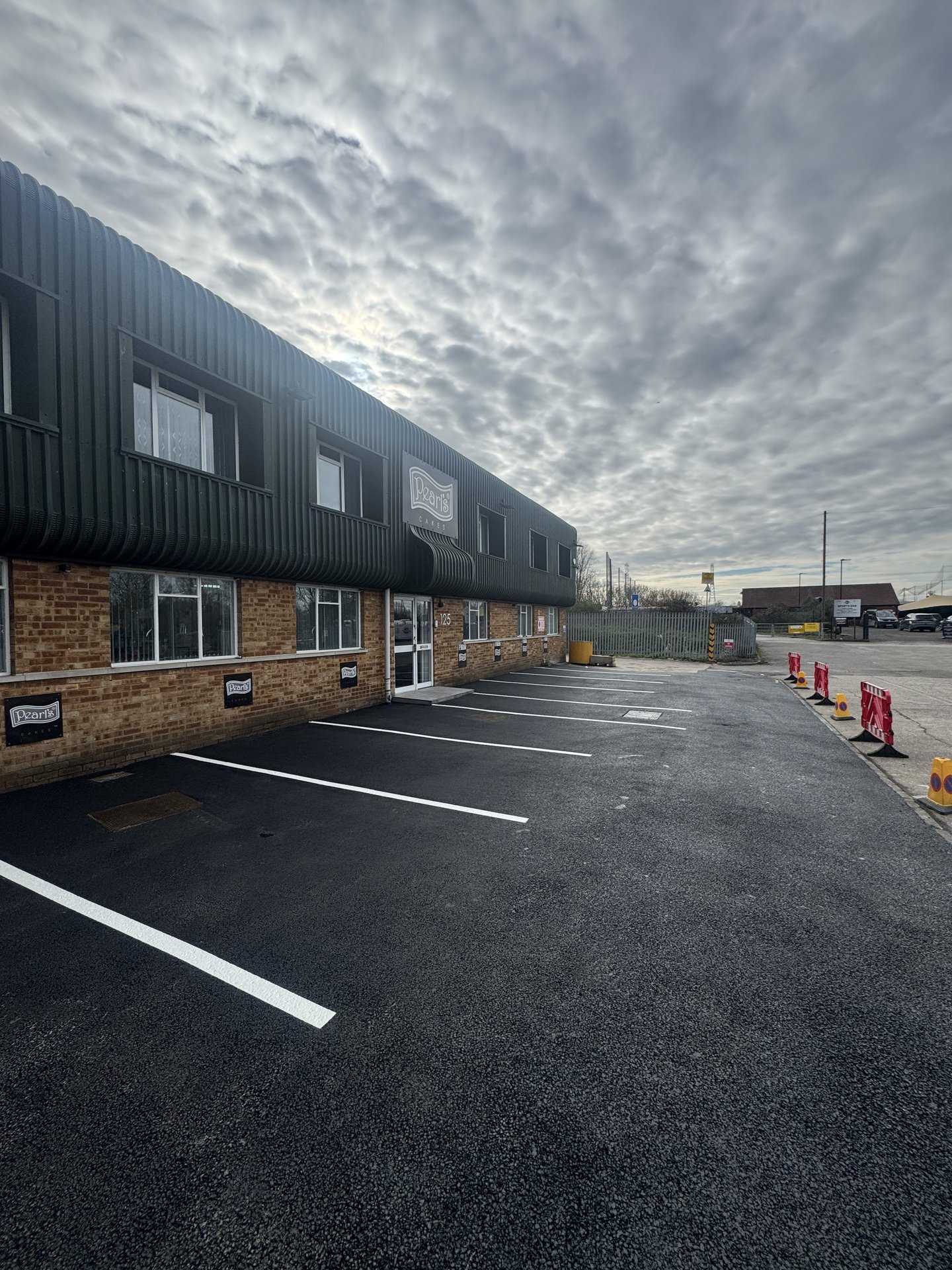 Marked parking bays on new asphalt at Pearls Cakes